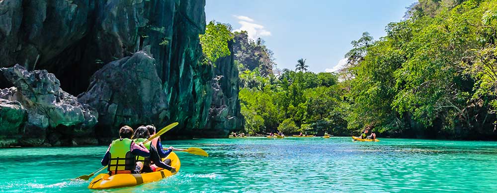 Kayaks in the big lagoon with turquoise clean water, tropical forest , rocks,, El Nido, Palawan, Philippines